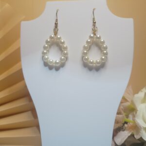 Brincos com pérolas em argola oval e peças e base anzol na cor dourada