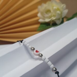 Pulseira Love com contas de vidro brancas leitosas, contas prateadas e fios na cor preta com fecho em macramê ajustável