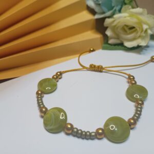 Pulseira com fio na cor dourada com pastilhas e miçangas cor verde oliva e contas metálicas em ouro velho com fecho em macramê ajustável
