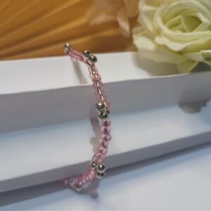 Pulseira com miçangas rosa claro brilhantes e contas metálicas na cor prata com forma de cerejas