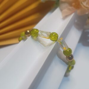 Pulseira de silicone com contas sextavadas na cor verde, contas de vidro na cor verde com dourado e muranos rajados de branco, amarelo e verde e contas metálicas douradas