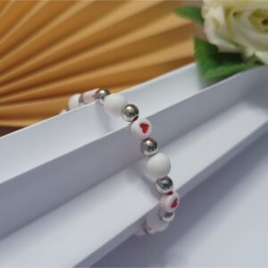 Pulseira de silicone Love com detalhes de corações em vermelho, contas brancas foscas e contas metálicas na cor prata
