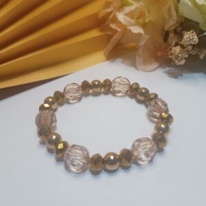 Pulseira de silicone com cristais sextavados dourados, contas na cor marrom translúcido e contas metálicas douradas