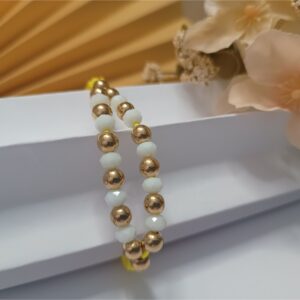 Pulseira em macramê amarela com detalhe em zigue zague de contas metálicas douradas e cristais na cor branca e fecho ajustável