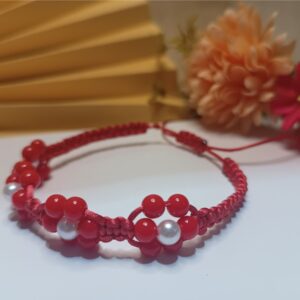 Pulseira trabalhada em macramê com fio de seda vermelho, flores em contas vermelhas e pérolas com fecho ajustável