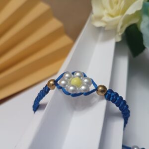 Pulseira trabalhada em macramê com fio na cor azul royal com flor central em perolas, contas em ouro velho e fecho ajustável