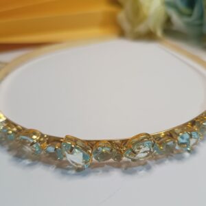 Tiara folheada a ouro 18k com cristais na forma de  gota na cor azul água marinha e aplicações de strass