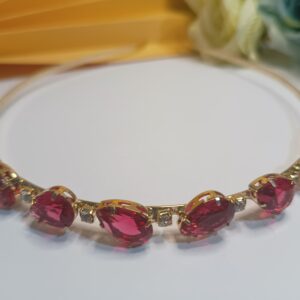 Tiara folheada a ouro 18k com cristais na forma de  gota na cor vermelha e aplicações de strass