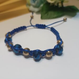 Pulseira em macramê com cristais azuis petróleo e contas metálicas douradas